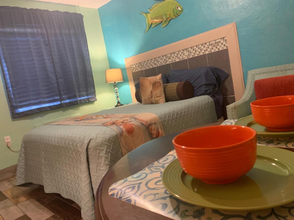 een slaapkamer met een bed en een tafel met een kom erop bij Michaels Siesta Studios in Redington Shores