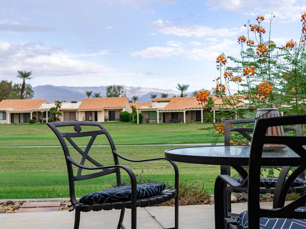 two chairs and a table in front of a yard at Desert Dream in Palm Desert