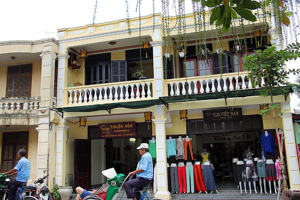 two men riding motorcycles in front of a building at Harmony Hoian Homestay in Hoi An