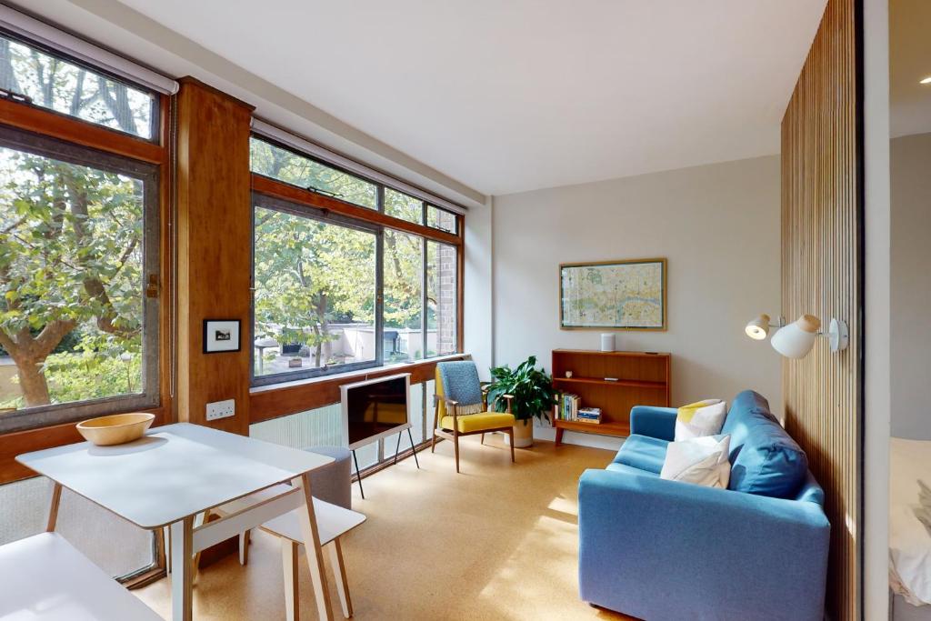 a living room with a blue couch and a table at Spacious 1 bedroom apartment in Kennington in London