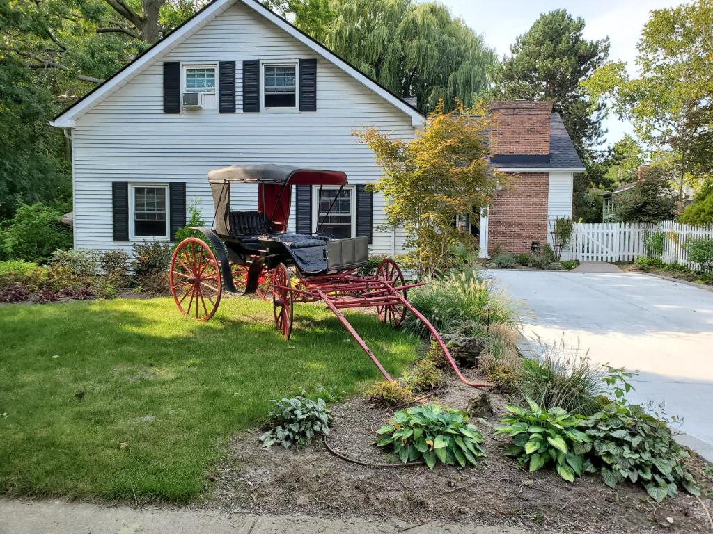 uma carruagem vermelha no pátio de uma casa em Upper Canada Coach House em Niagara-on-the-Lake