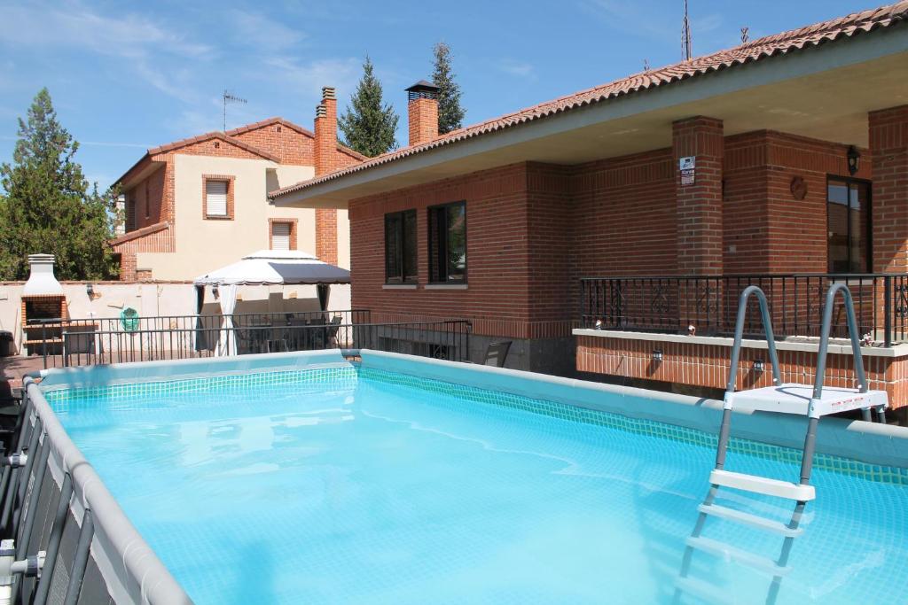 una piscina en un balcón con una casa en Aire De Pinares, en Coca