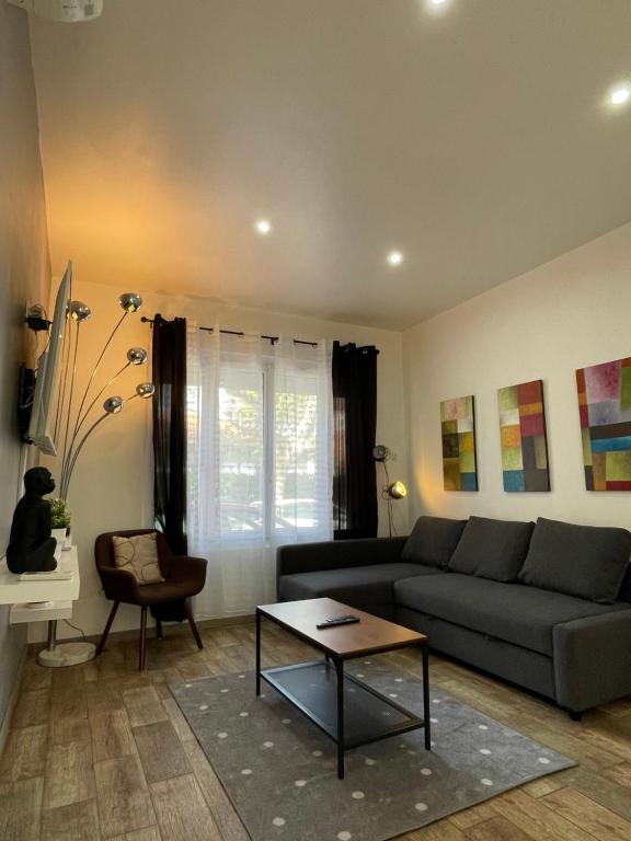 ein Wohnzimmer mit einem Sofa und einem Tisch in der Unterkunft La Seyne sur mer grande terrasse wifi clim, 2 chambres in La Seyne-sur-Mer