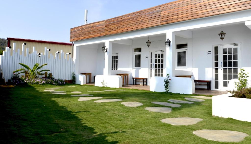 a yard with stepping stones in front of a house at Love Summer Hostel in Hengchun South Gate