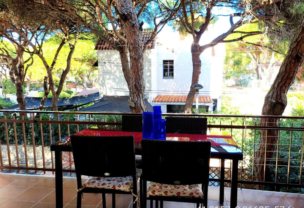 una mesa y sillas sentadas en un balcón con árboles en Apartament en Platja d'Aro al lado del mar en Platja  d'Aro