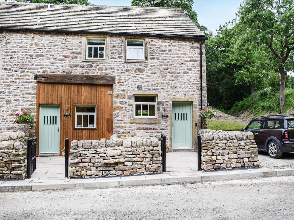 a stone house with green doors and a stone wall at Beckett Lodge - Uk34233 in Barrowford