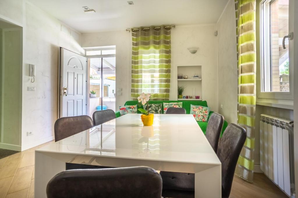 une salle à manger avec une table et des chaises blanches dans l'établissement RomaDamare, à Passoscuro