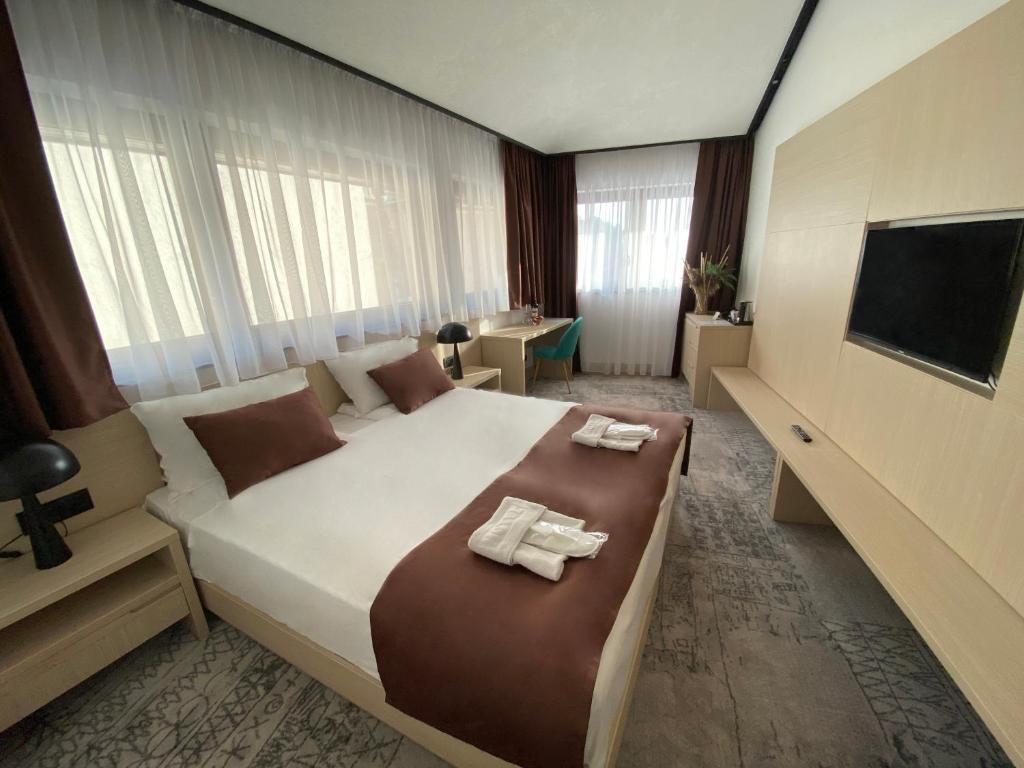 een slaapkamer met een groot bed en 2 handdoeken bij Hotel Boss in Sarajevo