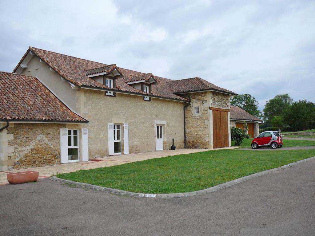 ein Haus mit einem roten Auto, das davor geparkt ist in der Unterkunft Chambre d'hotes "Les Bordes" in Marzy