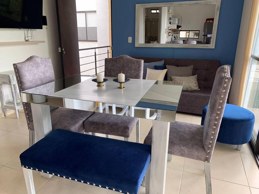 a dining table and chairs in a living room at G307Espectacular Apartamento, Condominio Campestre in La Tebaida