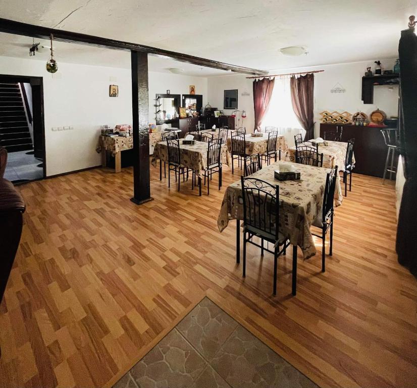 Pokój ze stołami i krzesłami na drewnianej podłodze w obiekcie Casa Albac w Albacu