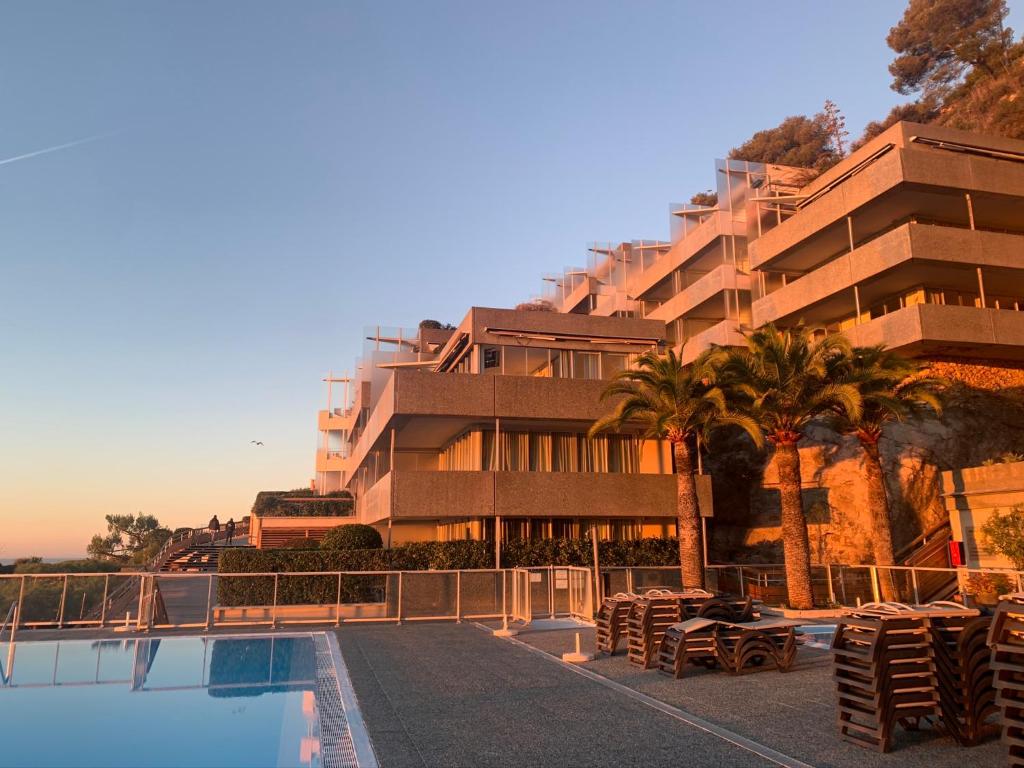 a hotel with a swimming pool and a building at SARA RIVIERA Costa Plana in Cap d'Ail