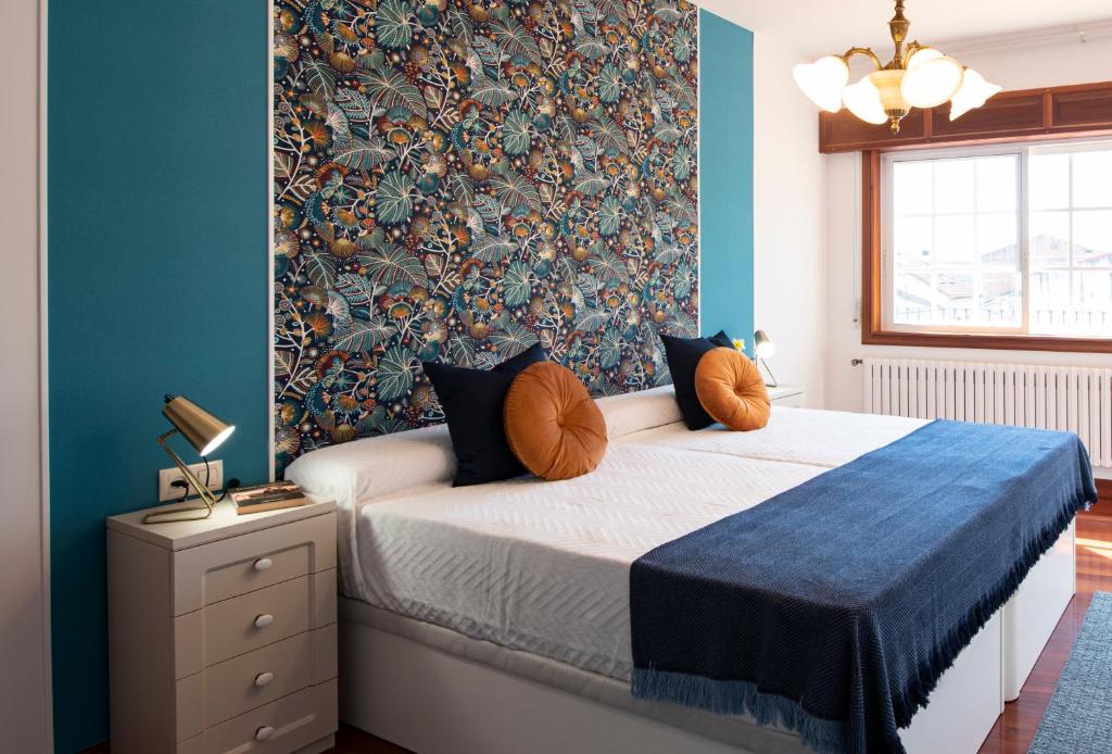 um quarto com uma cama com uma parede azul em Luxury Singular Villa Rosa em Padrón