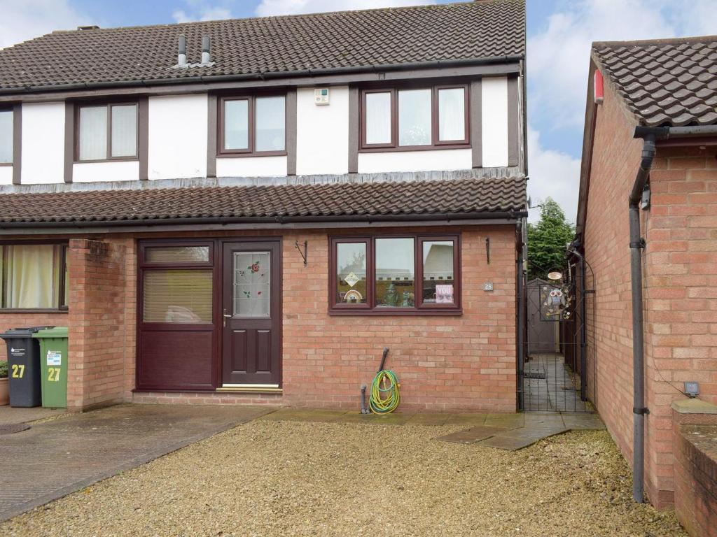 a white and red brick house with a garage at Withybrook Cottage in Hereford