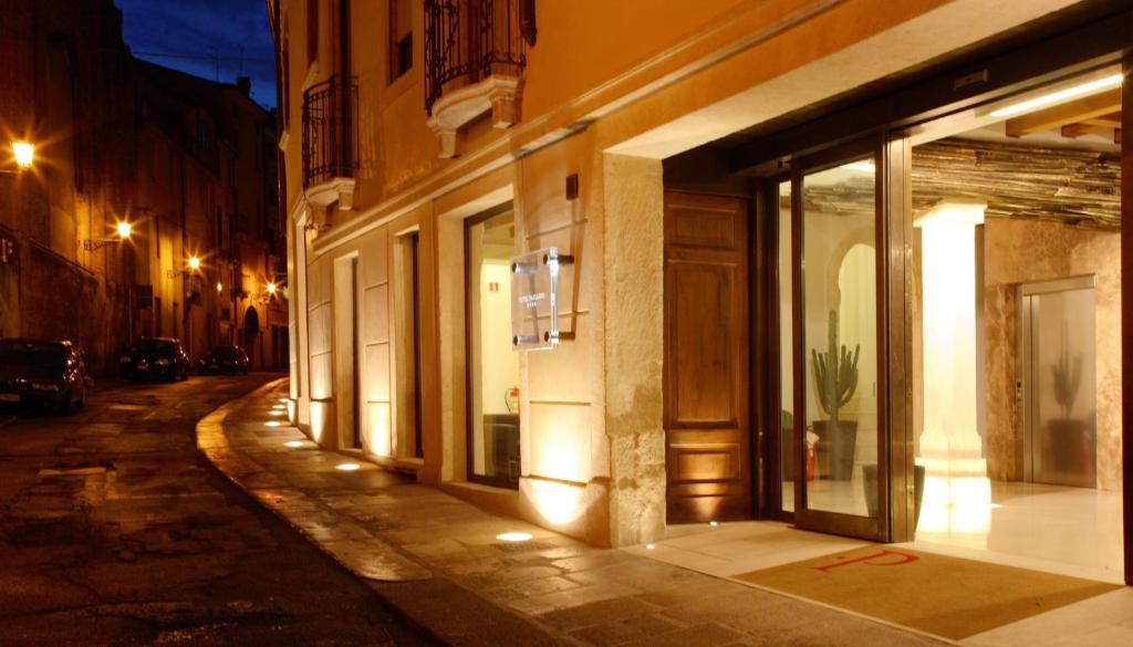 an empty city street at night with a store at Hotel Palladio in Vicenza