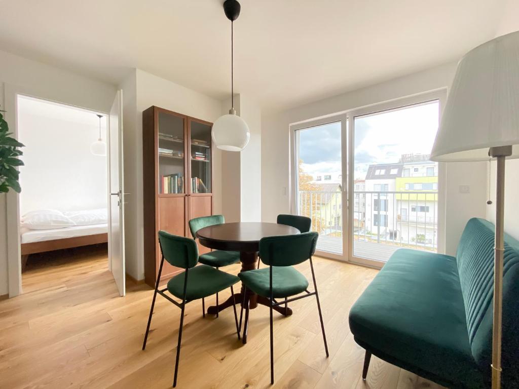 ein Esszimmer mit einem Tisch und grünen Stühlen in der Unterkunft STAD10 - Apartments very close to subway U2 Stadlau in Wien