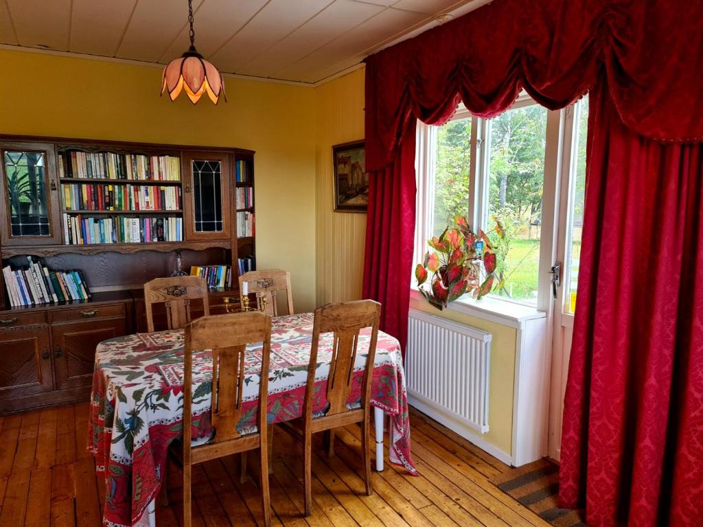 uma sala de jantar com uma mesa e uma janela em Vanneberga gamla skola em Fjälkinge