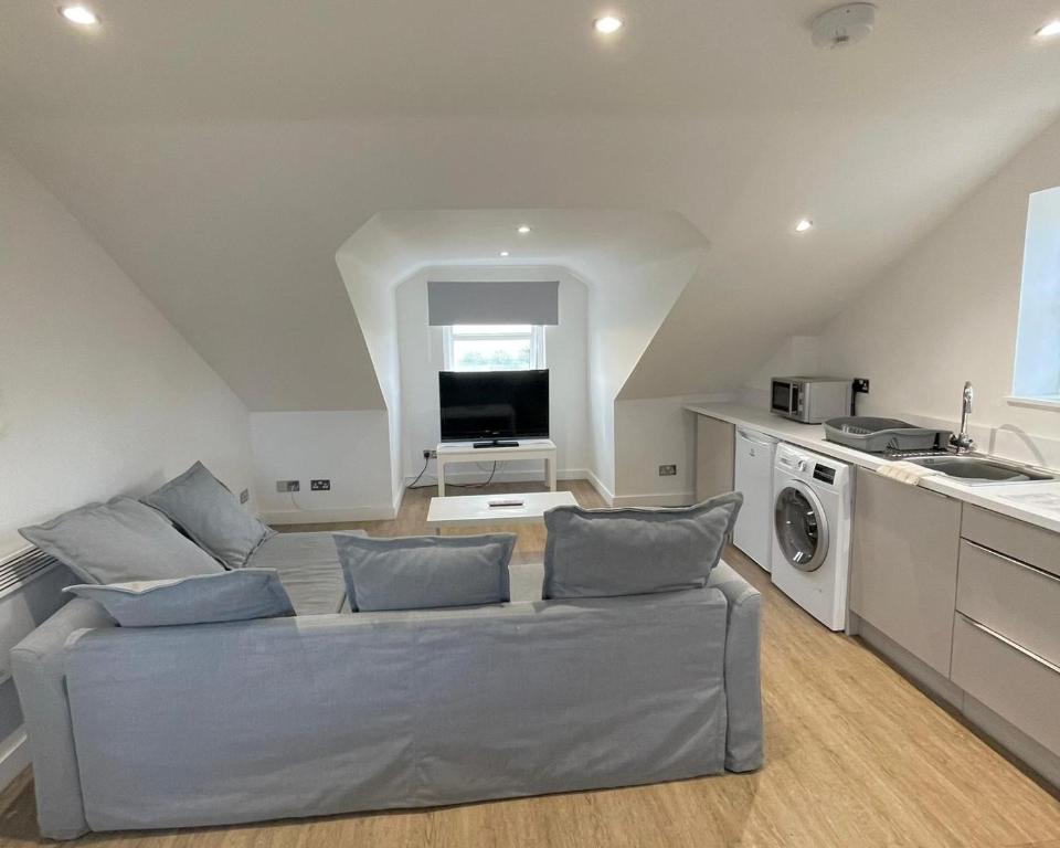 sala de estar con sofá y cocina en La Fontaine Court Apartments - Aldershot, en Aldershot