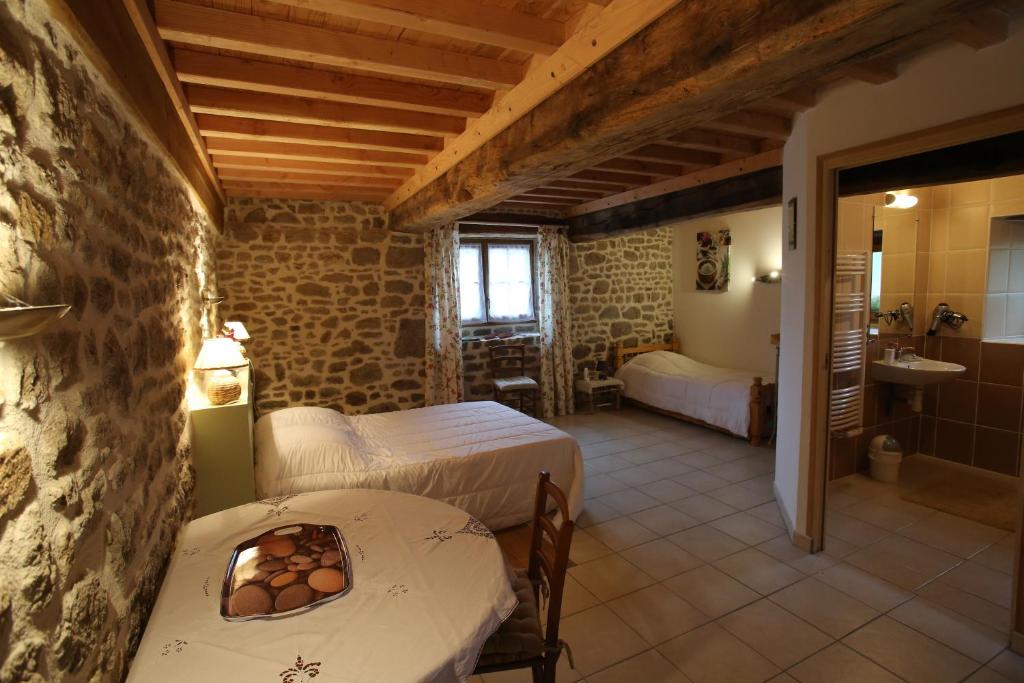 a bedroom with two beds and a bathroom with a sink at Ferme Cidricole Hugues Desfrièches in Sainte-Marguerite-de-Carrouges