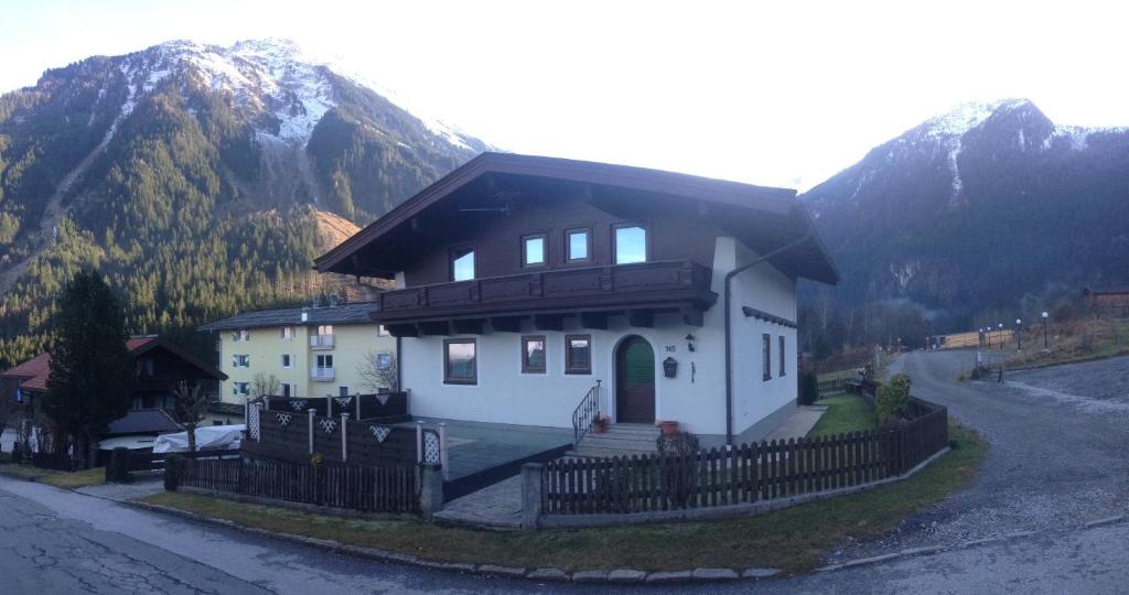 una casa con una valla delante de una montaña en Landhaus Vier Jahreszeiten en Krimml