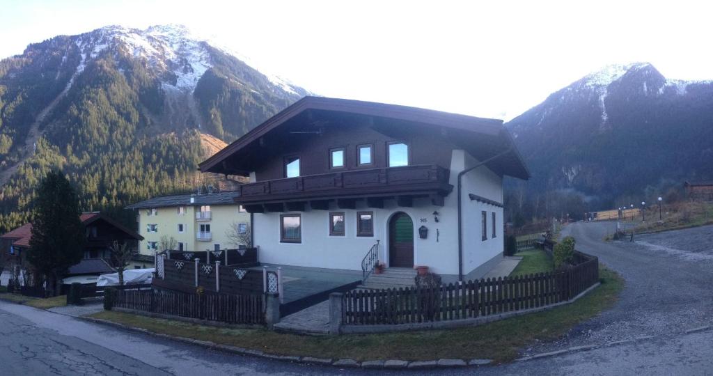 a house with a fence in front of a mountain at Landhaus Vier Jahreszeiten in Krimml