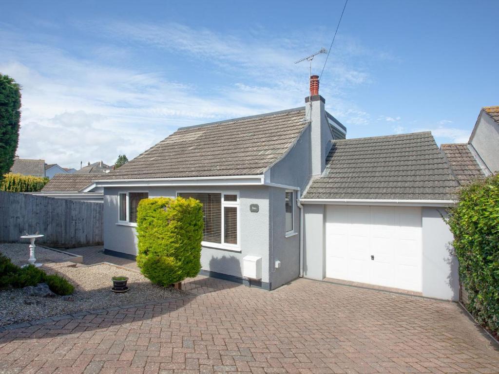 a white house with a garage on a brick driveway at Harbour Heights in Brixham