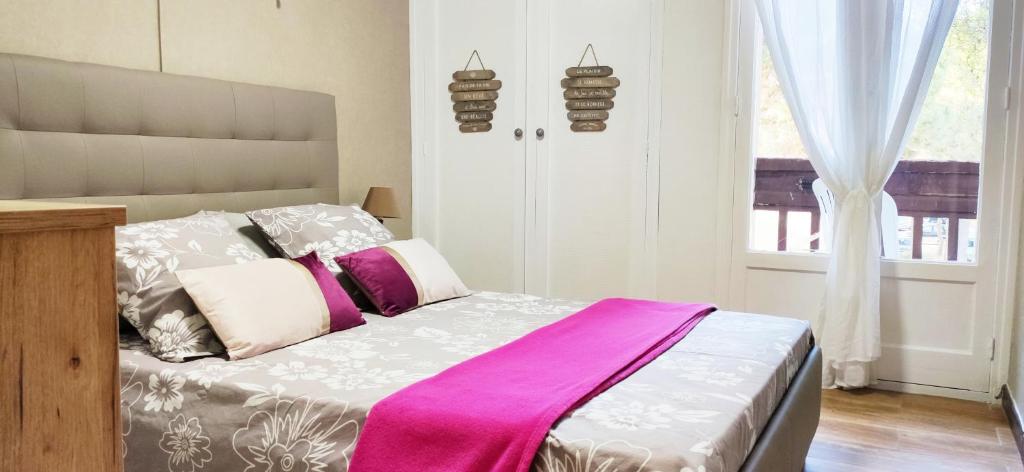 - une chambre avec un lit recouvert d'une couverture rose dans l'établissement Chaleureux T2 rénové Mer à 2 pas WIFI BALCON, à Plage dʼArgelès