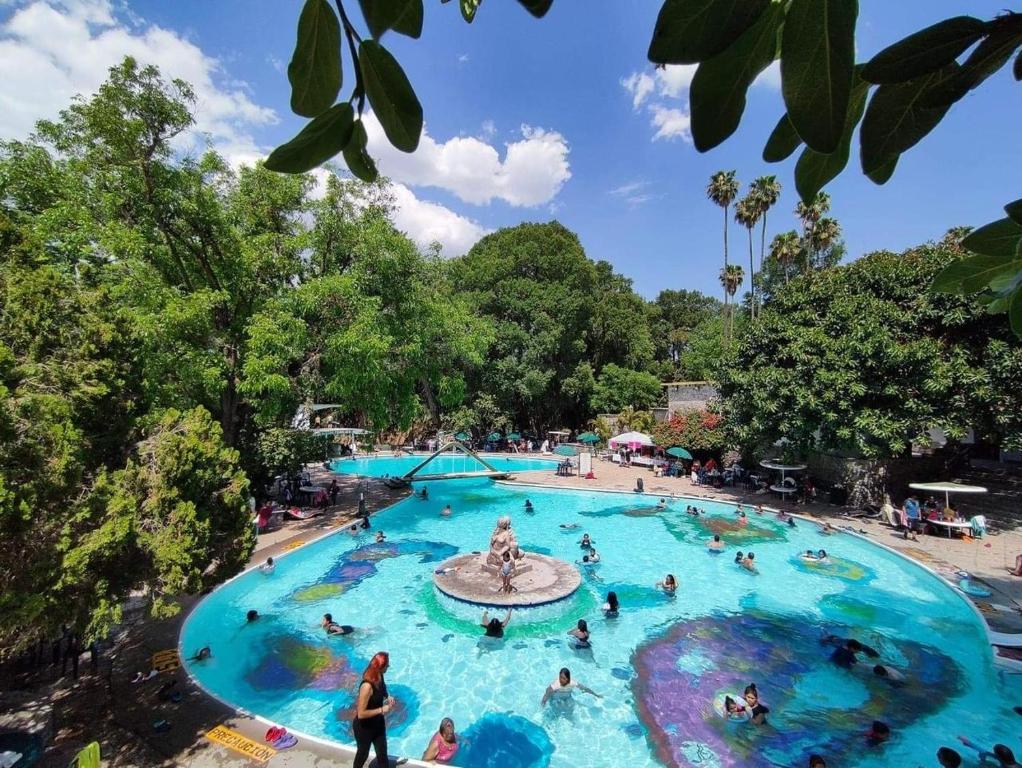 una gran piscina en un parque temático con gente dentro en Hotel Balneario Tzindejeh, en Tasquillo