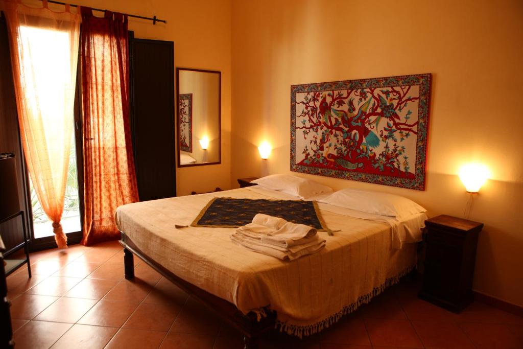 una camera da letto con un letto e un dipinto sul muro di Art Lincoln a Palermo