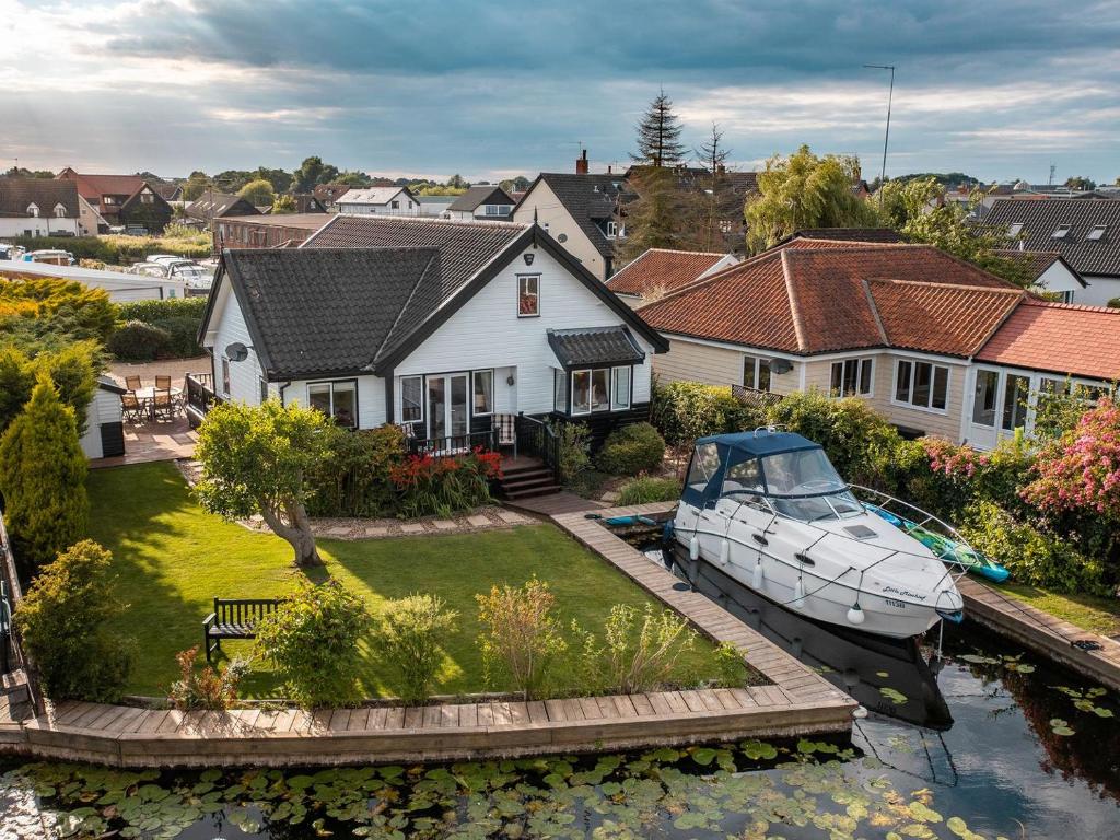 a boat is docked in the yard of a house at The Reeds in Wroxham