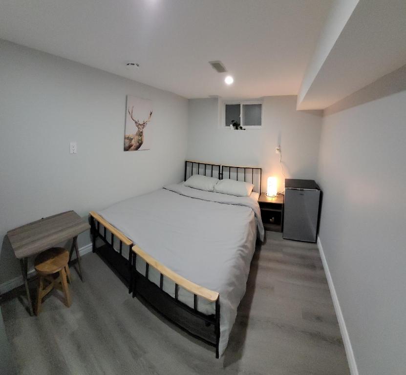 1 dormitorio con 1 cama grande, mesa y escritorio en Guest House Basement - Master Bedrooms in Bayview Village, en Toronto