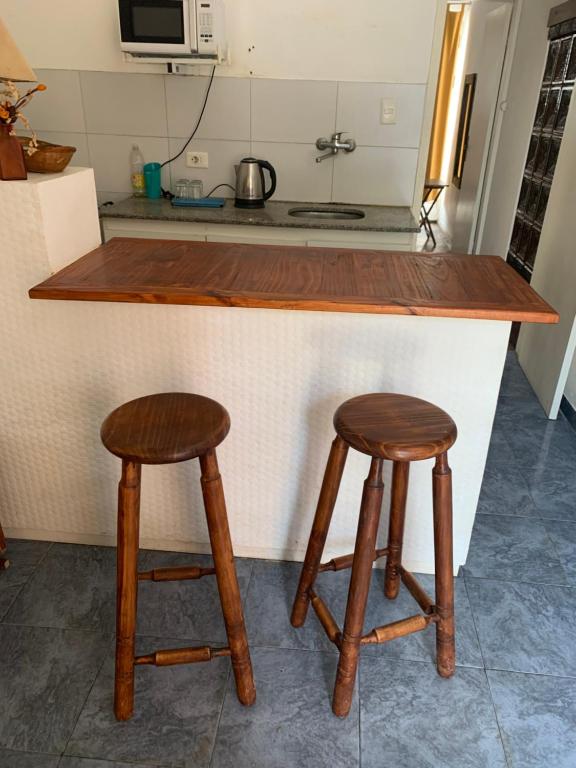 a kitchen with two wooden stools at a counter at Pequeño y cómodo in Florida
