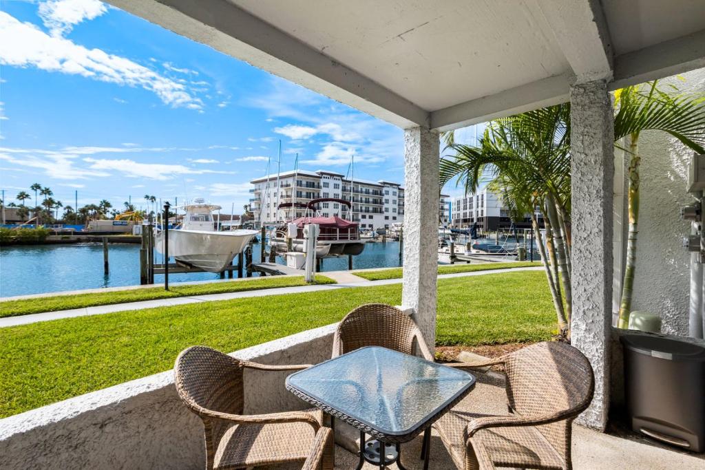 a table and chairs on a porch with a view of the water at #231 E Madeira Beach Yacht Club in St Pete Beach