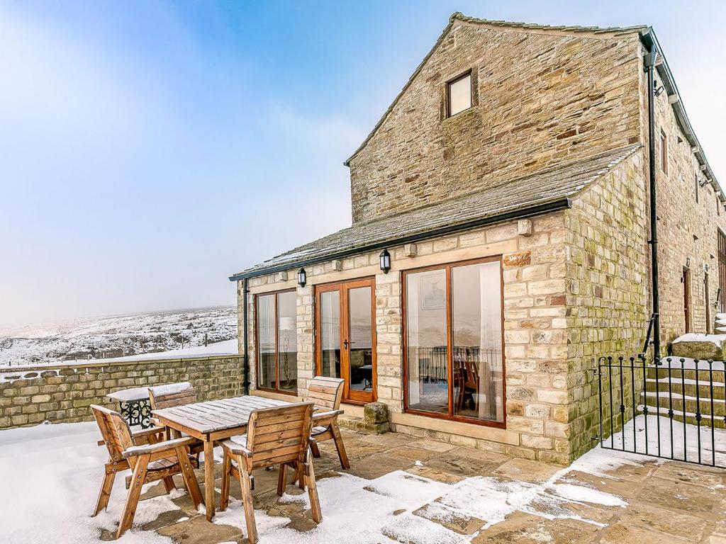 a stone house with a table and chairs at Waters Edge - Uk32390 in Dunford Bridge