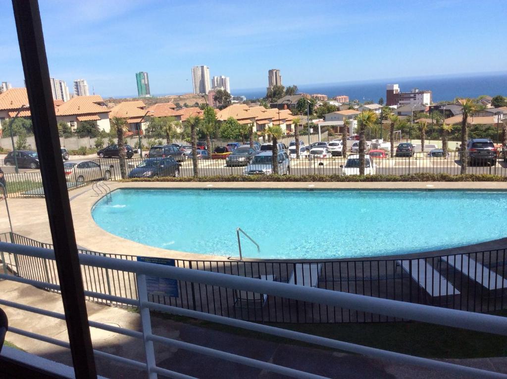 - une piscine avec vue sur un parking dans l'établissement Apartment Concón, à Concón