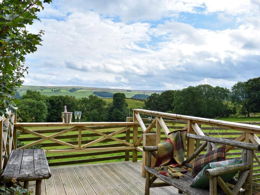 a wooden bench on a deck with a wooden fence at Hadrians Garden Cottage - Uk3323 in Bardon Mill