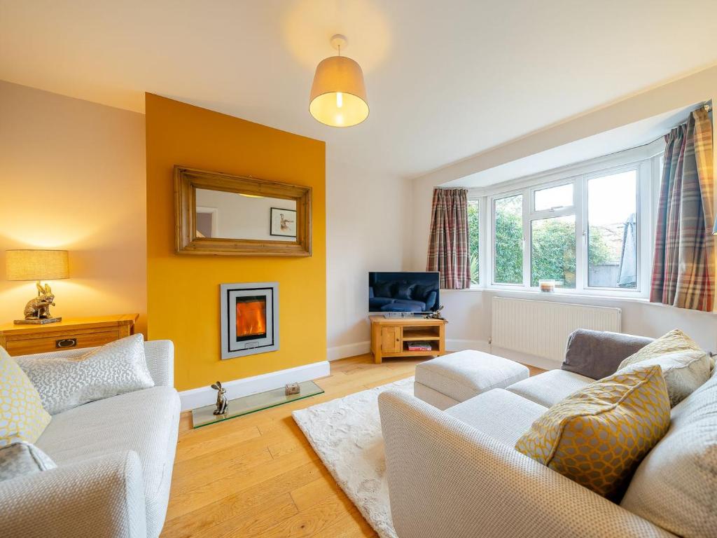 a living room with two white couches and a tv at Hare Bee Bee in Stratford-upon-Avon