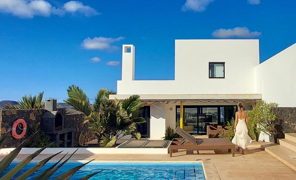 a woman walking in front of a villa at Sand Volcano Villa 2 in La Oliva