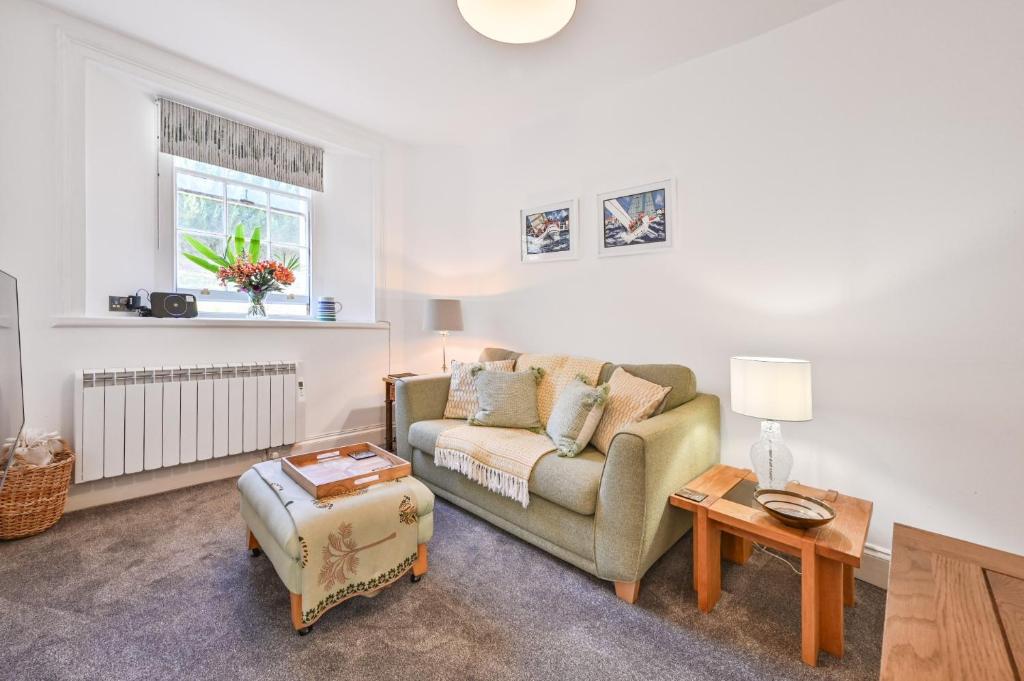 ein Wohnzimmer mit einem Sofa und einem Tisch in der Unterkunft Tramontane Apartment at Hesketh Crescent in Torquay