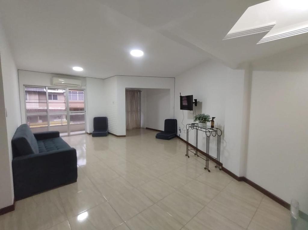 uma sala de estar com um sofá e cadeiras num edifício em Apartamento amplo pé na areia - Itapema 180m da Praia em Itapema