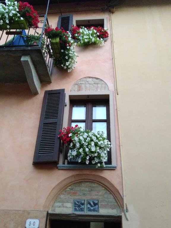 budynek z dwoma oknami i skrzyniami kwiatowymi w obiekcie Holiday House Antica Dimora Soggiorni in langa centro storico La Morra w mieście La Morra