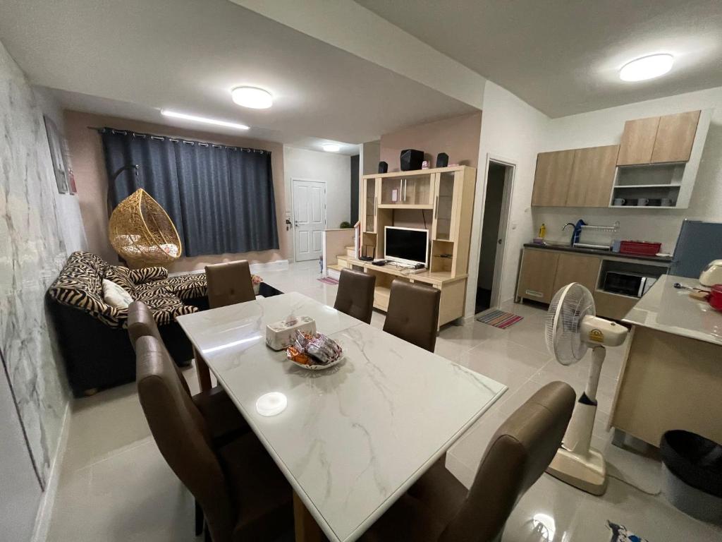 eine Küche und ein Wohnzimmer mit einem Tisch und Stühlen in der Unterkunft M Villa @ Impact Muangthongthani in Ban Bang Phang