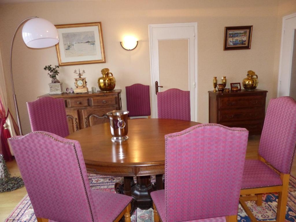 jadalnia z drewnianym stołem i fioletowymi krzesłami w obiekcie Résidence Saint-Nicolas Granville w mieście Granville