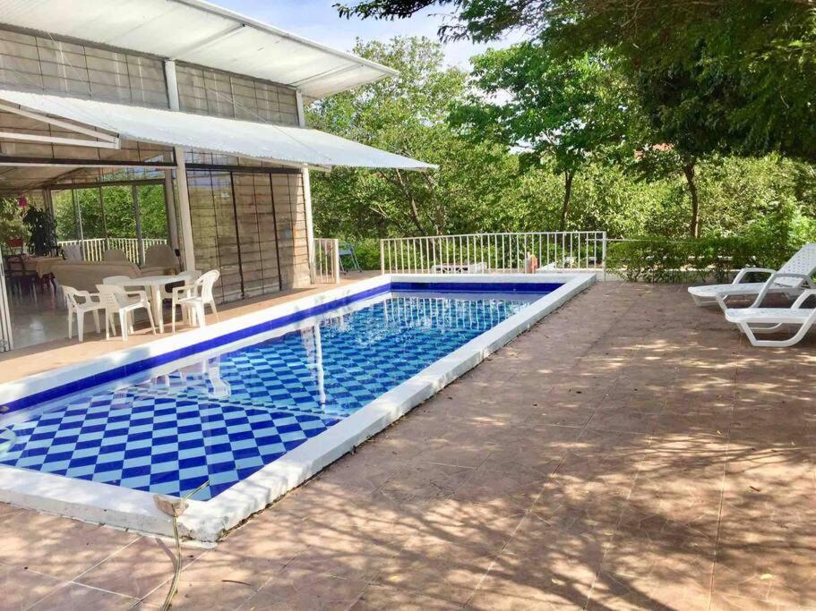 a swimming pool in front of a house at Finca La Felicidad in Tocaima