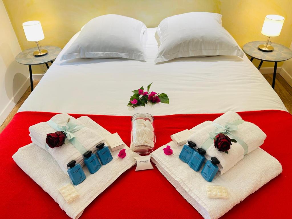 a bed with white towels and flowers on it at Le Jardin croix Roussien in Lyon