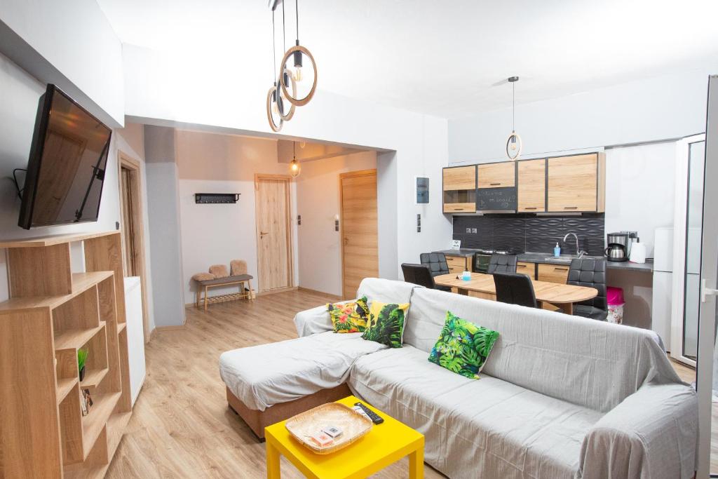 a living room with a couch and a kitchen at MATILDA Central Apartment in Egina