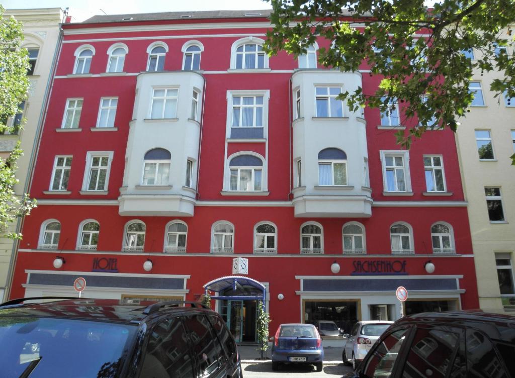 um edifício vermelho com carros estacionados em frente em Hotel Sachsenhof em Berlim