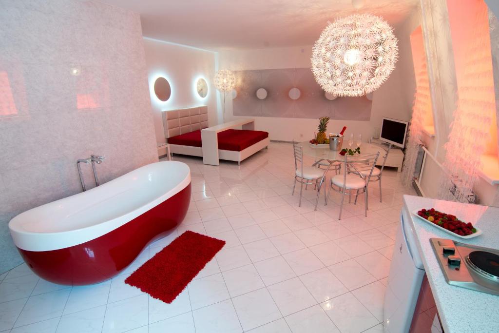 a bathroom with a large tub and a living room at Dragomir Apartments in Cherkasy