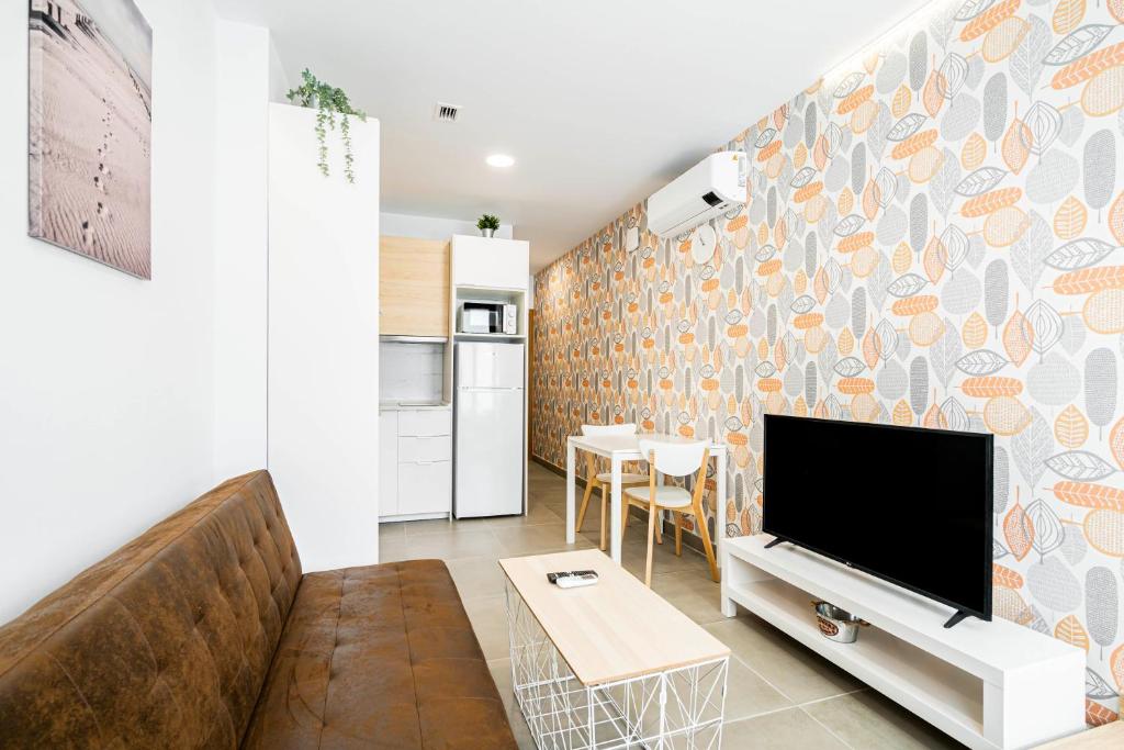 a living room with a couch and a flat screen tv at dobohomes - Horcajuelo in Madrid