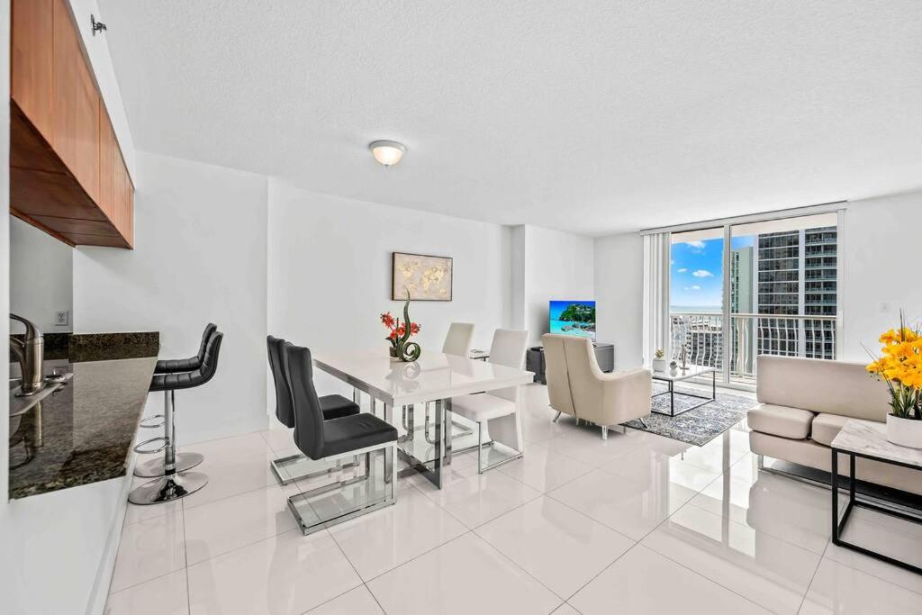 a white living room with a table and chairs at Luxurious 1 Bed Apartment in Brickell • Ocean View in Miami